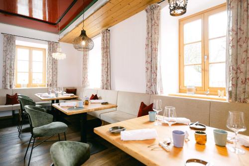 a restaurant with wooden tables and chairs and windows at Forthuber Waldhaus - Self Check-in möglich in Gstaig