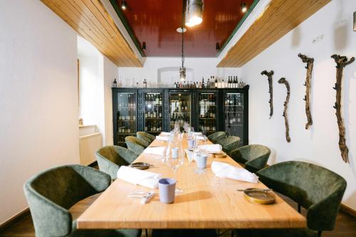 a dining room with a long table and green chairs at Forthuber Waldhaus - Self Check-in möglich in Gstaig