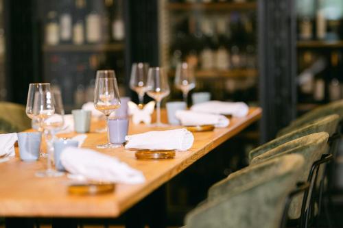 a long wooden table with wine glasses and napkins at Forthuber Waldhaus - Self Check-in möglich in Gstaig