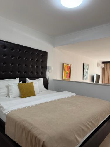 a bedroom with a large bed with a black headboard at Hotel Freiburg in Ulcinj