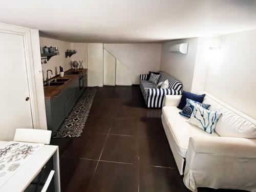 a living room with two couches and a kitchen at Casa Magica Ogliastro in San Marco di Castellabate