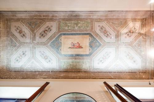 a ceiling in a building with a painting on it at UNYCA - La Loggia Suite in Florence