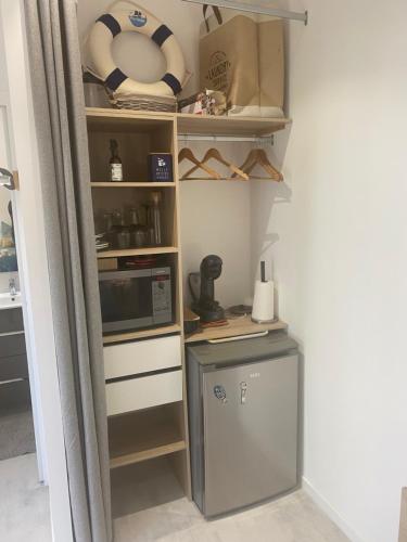 - une cuisine équipée d'un réfrigérateur et d'un four micro-ondes dans l'établissement Hébergement, à Ouistreham