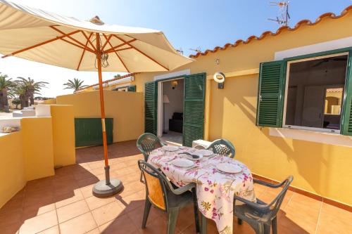 a table and chairs with an umbrella on a patio at Las siete palmeras - ciudadela in Cala en Blanes