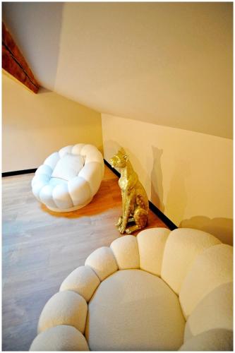 a cat sitting on the floor in a room at Duplex Safari jusqu'à 4 personnes, Spa XXL, day use, cinéma, cascade et lit sous les arbres in Bourgoin