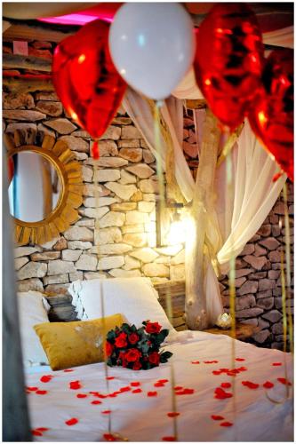 a room with a bed with roses and balloons at Duplex Safari jusqu'à 4 personnes, Spa XXL, day use, cinéma, cascade et lit sous les arbres in Bourgoin