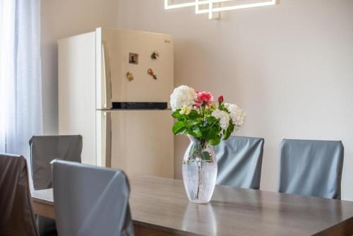 a vase of flowers on a table with a refrigerator at Theo House in Siena