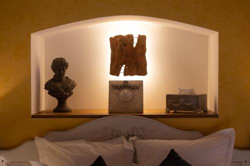 a light above a bed with statues on a shelf at Le Moulin de Beaunette in Grane