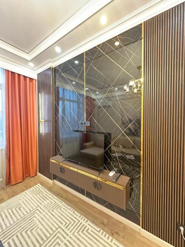 a living room with a couch and a television at Luxury apartment Astana Arena in Astana
