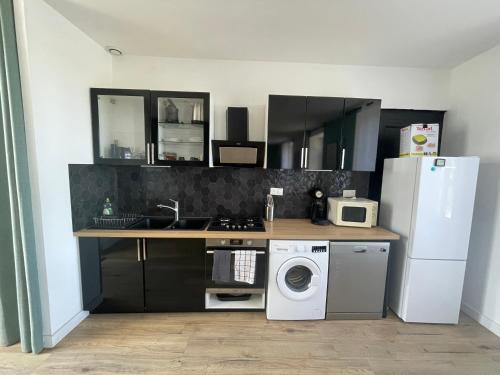 a kitchen with a refrigerator and a washing machine at Maison rénové bourg de Plourhan in Plourhan