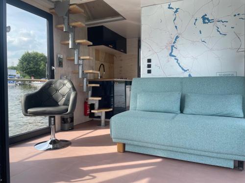 a living room with a blue couch and a chair at Hausbootneuruppin in Neuruppin