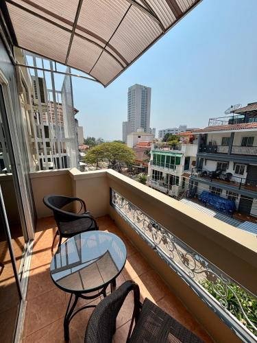 a balcony with chairs and a table on a balcony at Charm Hostel at Pratumnak in Pattaya South