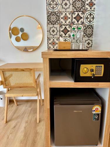 a table with a microwave and a chair in a room at Charm Hostel at Pratumnak in Pattaya South