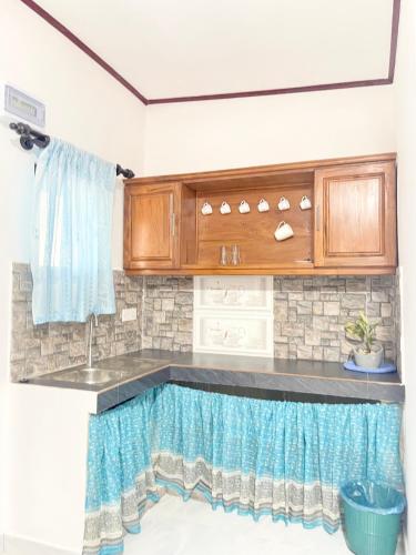 a kitchen with a sink and wooden cabinets at Villa Serenity in Negombo