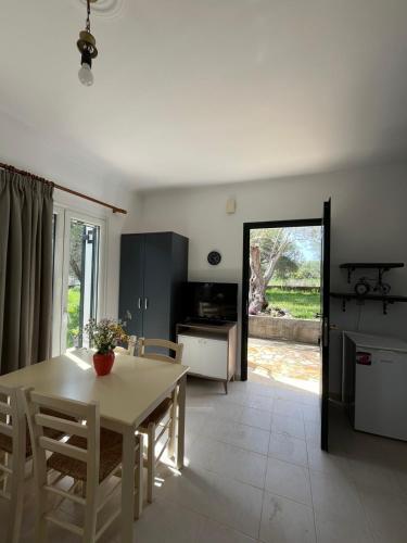 a kitchen and dining room with a table and chairs at Kouris Apartment Garden View in Chlomatianá