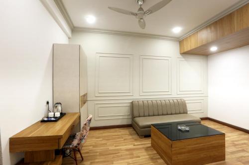 a living room with a couch and a table at Hotel Emerald Suites & Banquet By Aura in Noida
