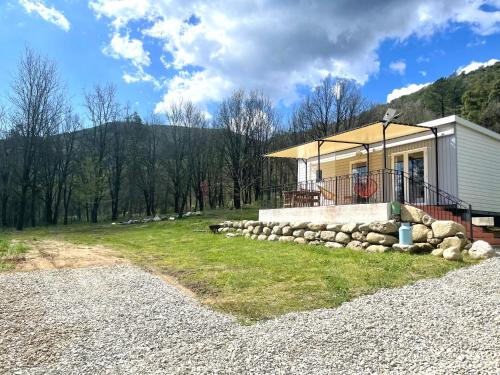 a small house on a hill with a gravel driveway at Bungalow à la campagne in Riventosa