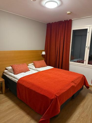 a bedroom with a large bed with a red blanket at Kylpyla SPA, Saimaa Villa 532 in Imatra