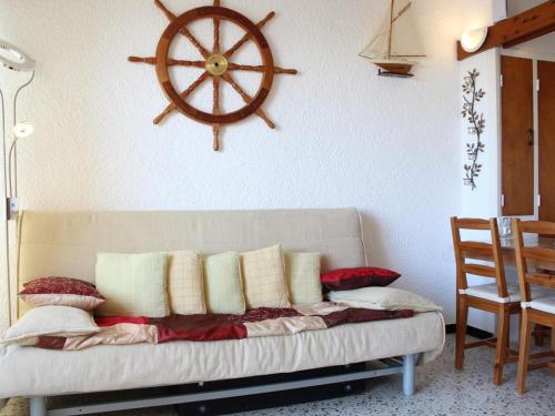 un salon avec un canapé et un volant sur le mur dans l'établissement Appartement 2 pièces proche plage, balcon, parking - FR-1-229C-107, à Port-la-Nouvelle