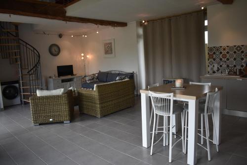 un salon avec une table, des chaises et un canapé dans l'établissement Le chant des oiseaux, à Ségonzac
