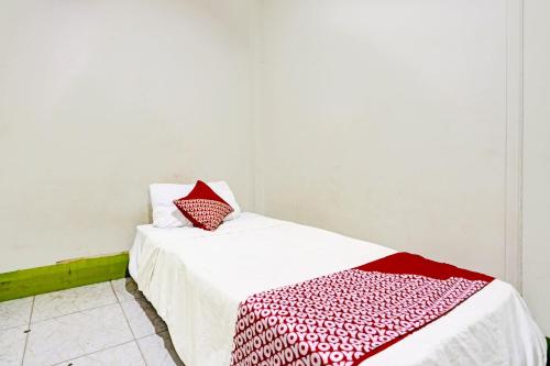 a white bed with a red and white blanket on it at Hotel O Suci Homestay SyariahNearKilas 7 TV in Tanjunguma