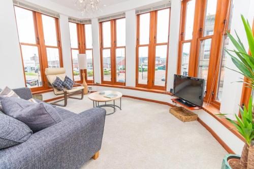 a living room with a couch and a tv at Central Dundee 2 Bed Apt near V&A Museum & City Attractions in Dundee