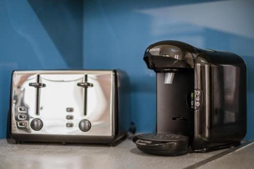 a coffee maker and a toaster sitting on a counter at Central Dundee 2 Bed Apt near V&A Museum & City Attractions in Dundee