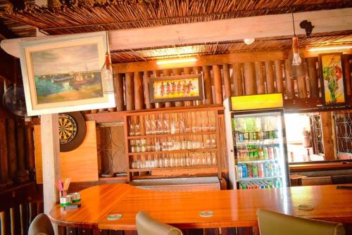a dining room with a table and a refrigerator at Nako Okavango Guesthouse in Ntabis