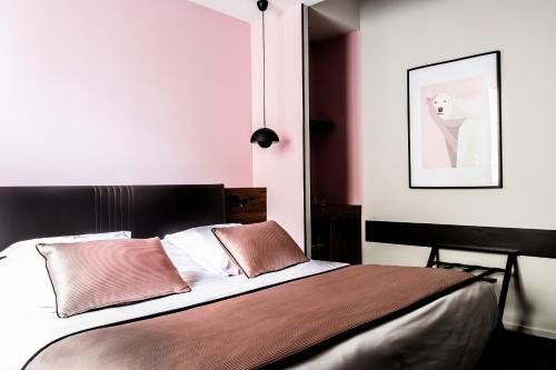 a bedroom with a bed with pink walls at Hostellerie Du Chapeau Rouge in Dijon
