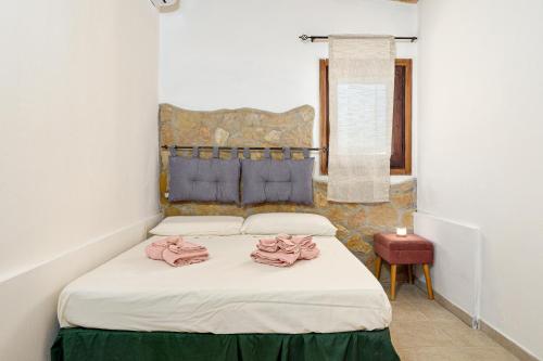 une chambre avec un lit avec des serviettes roses dessus dans l'établissement Elia's House, à Porto Istana