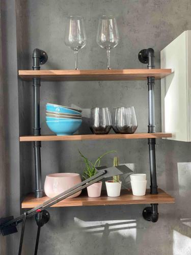 a shelf with bowls and wine glasses on it at Neuss Zentrum 70qm Maisonette-Wohnung in Stadthaus in Neuss