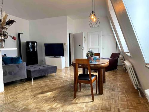a living room with a table and a couch at Neuss Zentrum 70qm Maisonette-Wohnung in Stadthaus in Neuss