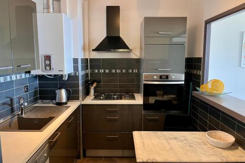 une cuisine avec un évier et une cuisinière dans l'établissement Dany - Apartment with large balcony and sea view, à Ajaccio