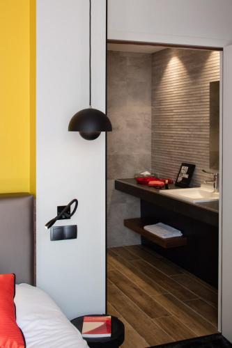 a bathroom with a sink and a vanity with a mirror at Hostellerie Du Chapeau Rouge in Dijon