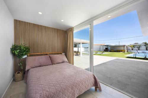 a bedroom with a bed and a large window at Villa Pablo in Chiclana de la Frontera
