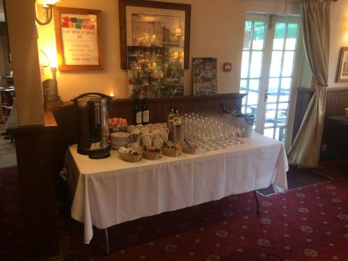a table with cups and wine glasses on it at The Wheatsheaf Inn in Cuckfield