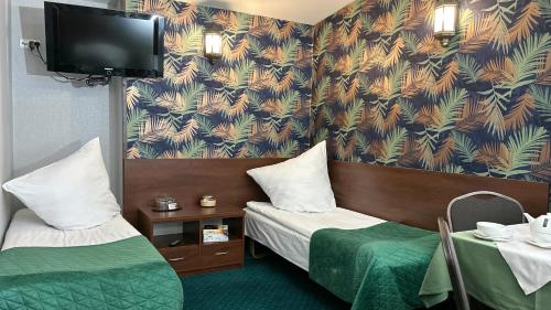 a hotel room with two beds and a flat screen tv at Noclegi I Restauracja Zodiak in Gliwice