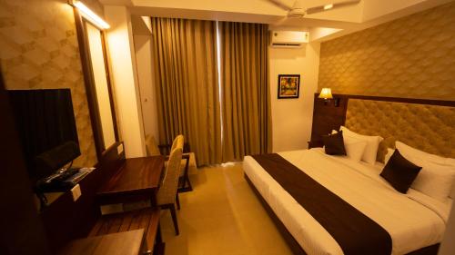 a hotel room with a bed and a desk at Dev Residency in Attingal