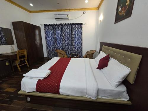 Un dormitorio con una cama grande con almohadas rojas y blancas. en Kudajadri Heritage Pool Homestay Kothamangalam, en Kotamangalam