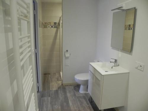 a white bathroom with a toilet and a sink at appartement avec 2 suites parentales in Angoulême