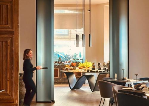 a woman walking through a door in a room at Palazzo Liberty Unique Hotel by Geocharme in Palermo