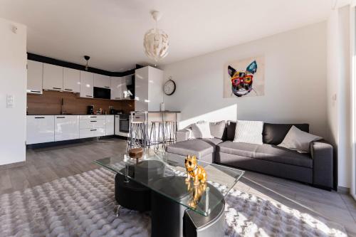 un salon avec un canapé et une table en verre dans l'établissement Les Jardins de la Semm - Parking et Jardin, à Colmar