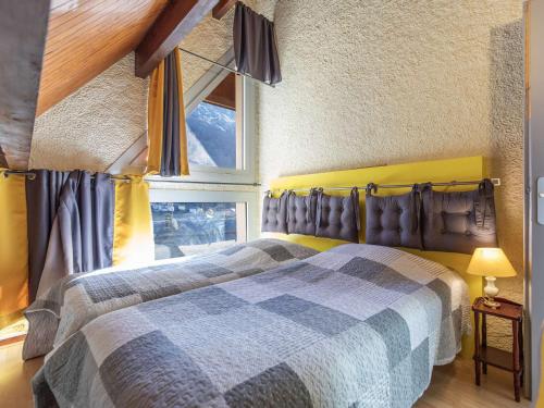 une chambre avec une tête de lit jaune et une fenêtre dans l'établissement Appartement T3 avec petite terrasse, 2 chambres, parking à Cauterets - FR-1-401-313, à Cauterets