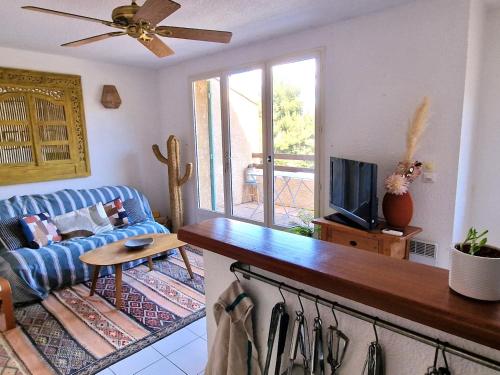un salon avec un canapé bleu et une télévision dans l'établissement Villa T3 Banyuls-sur-Mer, terrasses, garage - FR-1-309-498, à Banyuls-sur-Mer