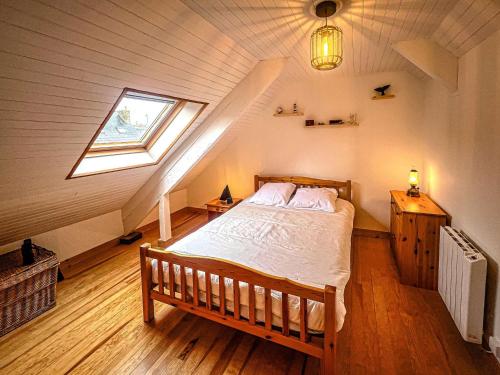 - une chambre mansardée avec une fenêtre dans l'établissement Étel - Maison rénovée 3 pièces cosy avec WiFi - FR-1-479-224, à Étel