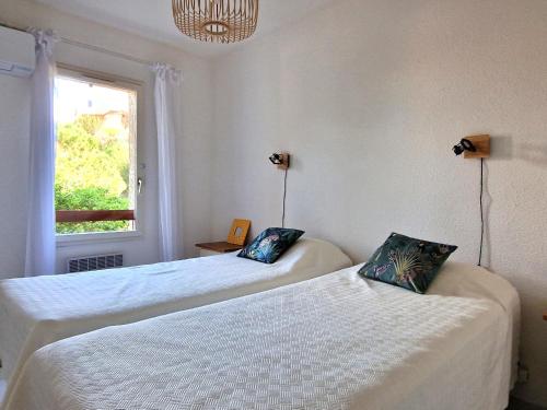 deux lits dans une chambre blanche avec une fenêtre dans l'établissement Villa T3 Banyuls-sur-Mer, terrasses, garage - FR-1-309-498, à Banyuls-sur-Mer