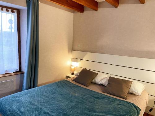 a bedroom with a large bed with a blue blanket at Gîte de charme pour 4 pers à Tour-en-Sologne, climatisé - FR-1-491-460 in Tour-en-Sologne