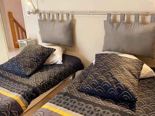 two beds sitting next to each other in a bedroom at Gîte confortable avec Wi-Fi, proche Zoo de Beauval et châteaux de la Loire - FR-1-491-458 in Meusnes