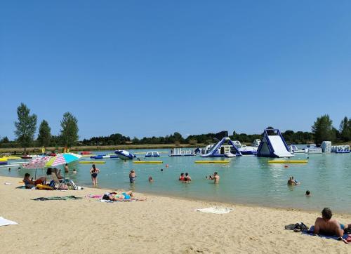 a group of people on a beach in the water at Charming comfortable barn in Coutras