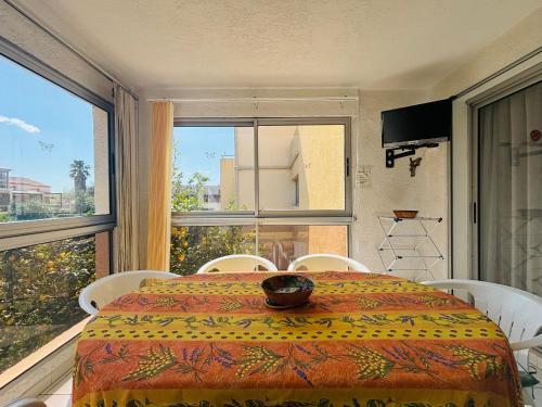 une pièce avec une table et des chaises et une grande fenêtre dans l'établissement Appartement T2 à Argelès-sur-Mer avec loggia, 4 couchages et piscine - FR-1-309-499, à Argelès-sur-Mer